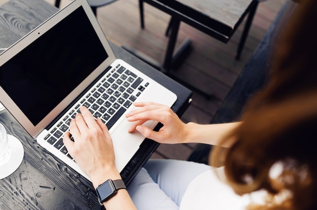 Geschäftsfrau, die Laptop an der Terrasse benutzt