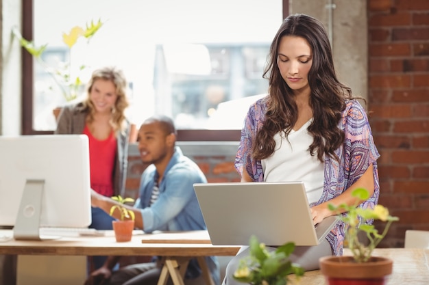 Geschäftsfrau, die Laptop im kreativen Büro verwendet