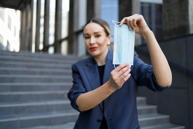 Geschäftsfrau, die medizinische Maske zeigt