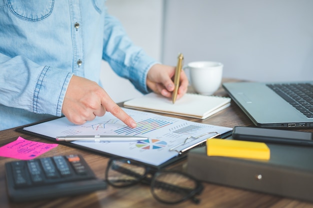 Geschäftsfrau, die mit dem Analysieren und der Planung der Finanzbuchhaltung auf Schreibtischbüro arbeitet.