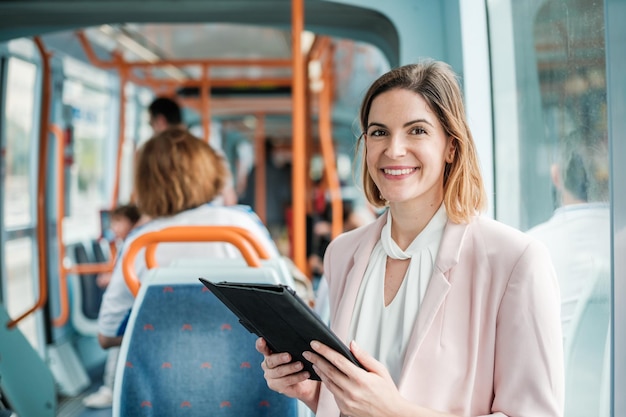 Geschäftsfrau, die mit dem Tablet aus der Anwendung arbeitet, während sie zu ihrer Arbeit im öffentlichen Verkehr geht Konzept Unternehmertum im öffentlichen Verkehr