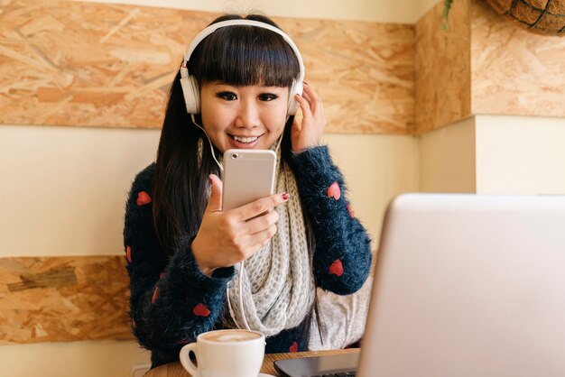 Geschäftsfrau, die Musik im Coffee Shop hört. Geschäftskonzept