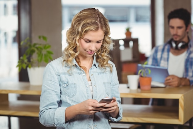 Geschäftsfrau, die Smartphone im Büro verwendet