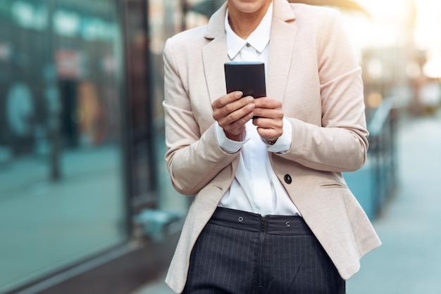 Geschäftsfrau, die Telefon hält und eine Nachricht schreibt