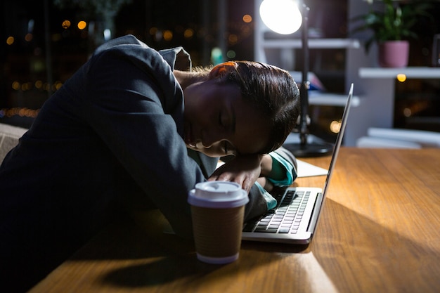 Geschäftsfrau, die während der Arbeit im Büro schläft