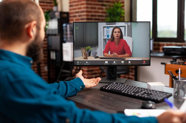 Geschäftsfrau diskutiert Managementstrategie mit Remote-Arbeitskollegin während der Online-Videokonferenzkonferenz auf dem Computer. Manager, der bei der Firmenpräsentation im Startup-Büro arbeitet. Telefonkonferenz