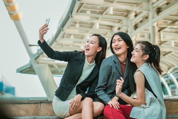 Geschäftsfrau Freunde Selfie mit Smartphone und zeigt auf den Bildschirm überrascht