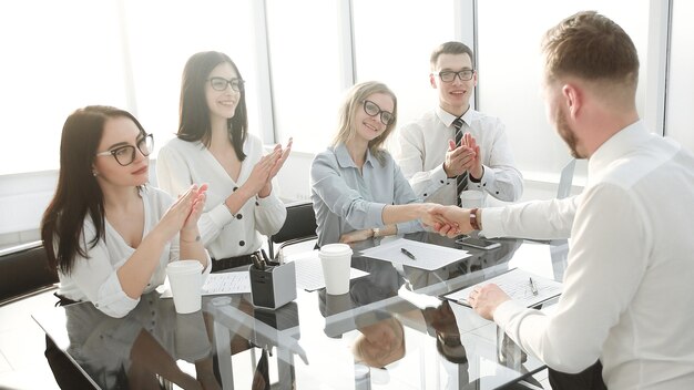 Geschäftsfrau gratuliert dem Mitarbeiter mit der Unterzeichnung eines neuen Arbeitsvertrags. das Konzept des Karrierewachstums