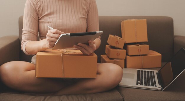 Geschäftsfrau gründet Kleinunternehmen, KMU-Erfolg, freiberufliche Frau, die zu Hause mit Online-Paketzustellungs-KMU und Verpackungszustellungskonzept arbeitet