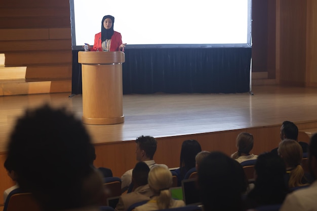 Geschäftsfrau hält eine Rede vor dem Publikum im Auditorium