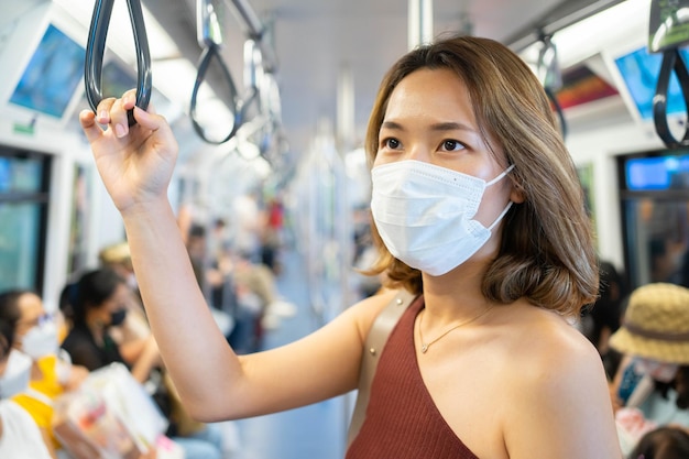 Foto geschäftsfrau hält handschlaufe in den öffentlichen verkehrsmitteln, um in der hauptverkehrszeit zur arbeit zu gehen