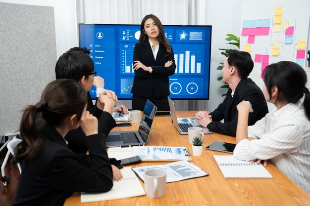 Geschäftsfrau hält Präsentation über Dashboard-Daten auf dem Bildschirm im Harmoniebüro