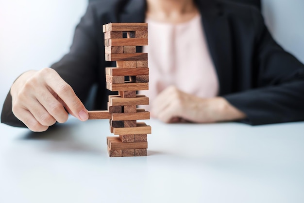 Foto geschäftsfrau hand platzieren oder ziehen holzblock auf dem turm unternehmensplanung risikomanagement lösung und strategiekonzepte