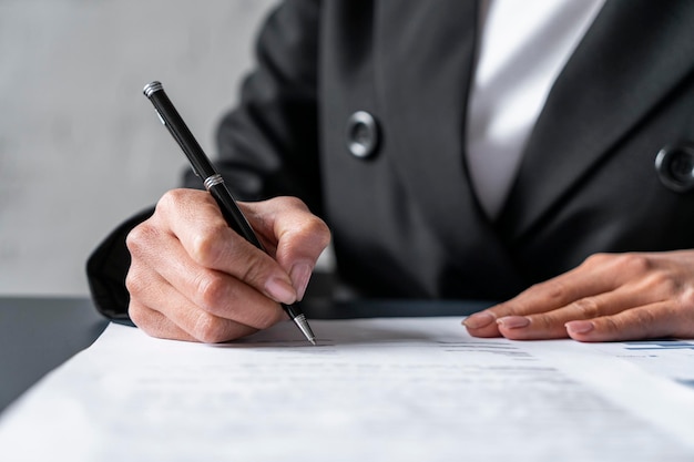 Geschäftsfrau Hand Unterzeichnung Vertrag am Tisch