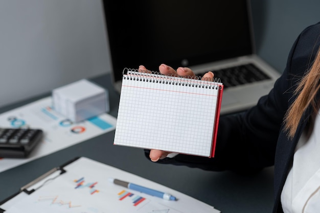 Foto geschäftsfrau holding hinweis mit wichtiger nachricht mit einer hand frau mit notebook mit entscheidenden informationen executive mit kritischen daten auf papier