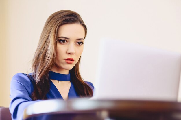 Geschäftsfrau im Büro hinter Laptop