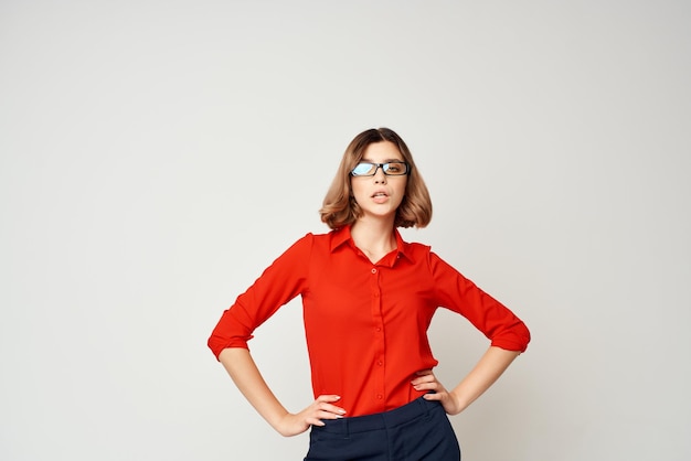 Geschäftsfrau in den Emotionen des roten Hemdes, die hellen Hintergrund aufwerfen