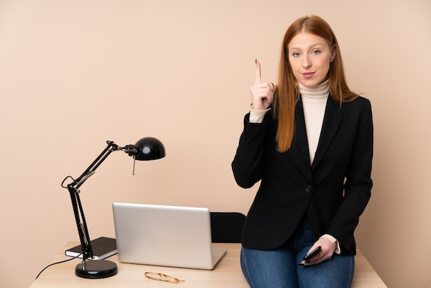 Geschäftsfrau in einem Büro, das mit dem Zeigefinger eine große Idee zeigt