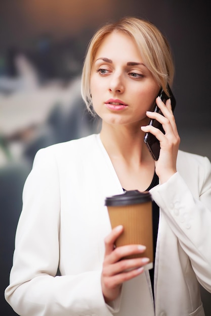 Geschäftsfrau-Manager trinkt Kaffee aus einem Pappbecher im Büro des Unternehmens.