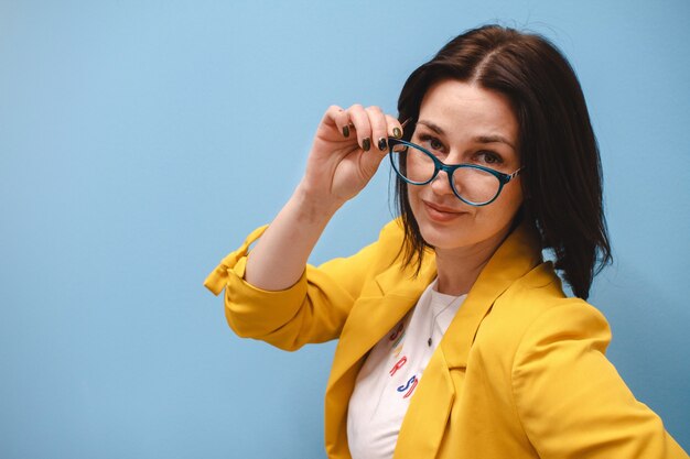 Geschäftsfrau mit Brille und überrascht über grauem Hintergrund.