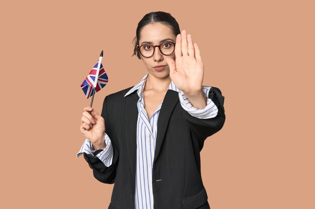 Geschäftsfrau mit britischer Flagge, die internationale Geschäfte symbolisiert, steht mit ausgestreckter Hand