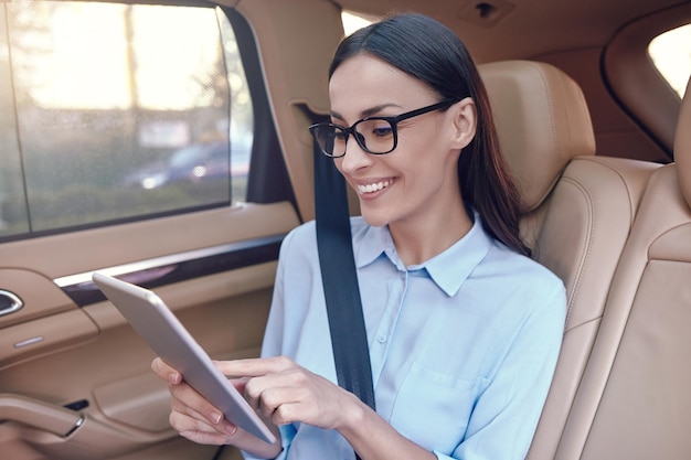 Geschäftsfrau mit digitalem Tablet im Auto sitzen