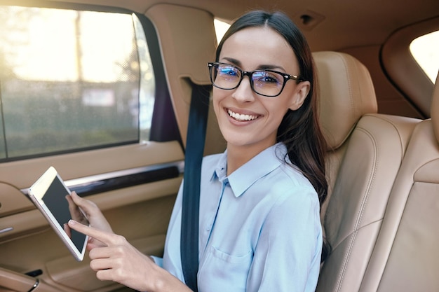 Geschäftsfrau mit digitalem Tablet im Auto