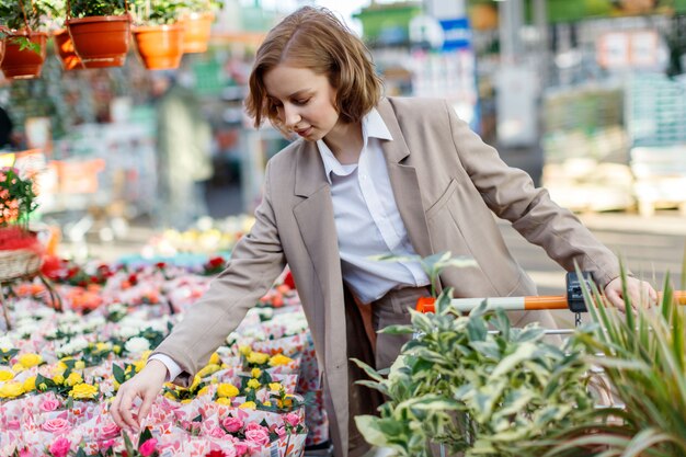 Geschäftsfrau mit Einkaufswagenauswahl, Kauf von Pflanzen für ihr Haus im Gartencenter.