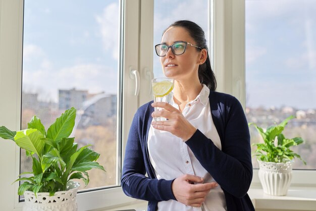 Geschäftsfrau mit Glas Wasser mit Zitrone