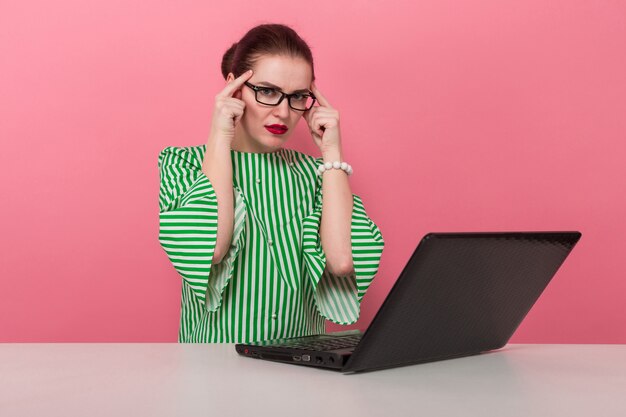 Geschäftsfrau mit Haarknoten und Laptop