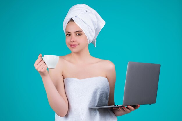 Geschäftsfrau mit Handtuch auf dem Kopf mit Kaffee, der am Laptop arbeitet Kaffee am Morgen Porträt des lächelnden w