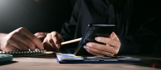 Geschäftsfrau mit Handy bei Bürobesprechung