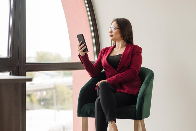 Geschäftsfrau mit Handy im Büro