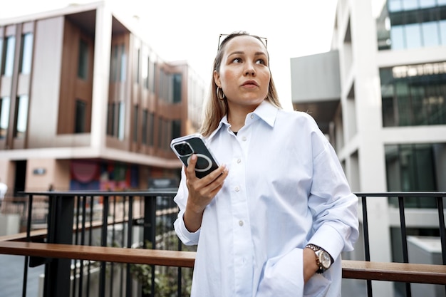 Geschäftsfrau mit ihrem Handy auf dem Balkon