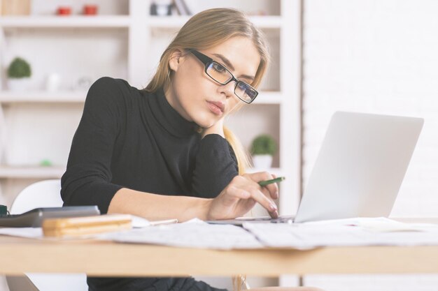 Geschäftsfrau mit Laptop am Schreibtisch