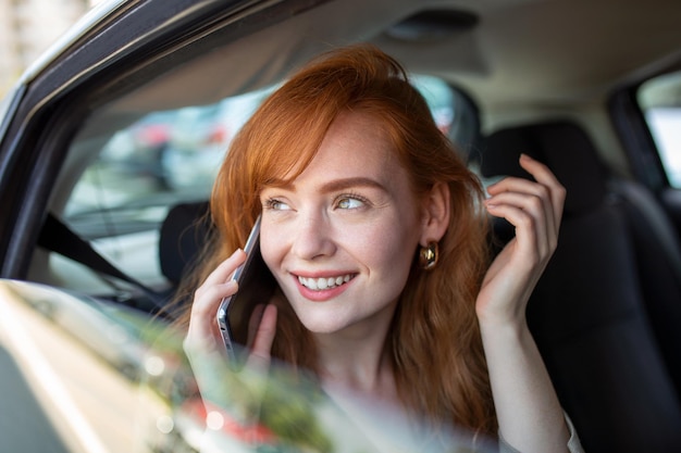 Geschäftsfrau Multitasking während der Fahrt am Telefon sprechen Lächelnde Frau spricht auf ihrem Telefon während der Fahrt Woman Talking on Mobile while Driving