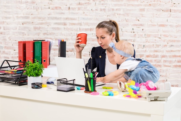 Foto geschäftsfrau-mutter-frau mit einer tochter, die am computer arbeitet