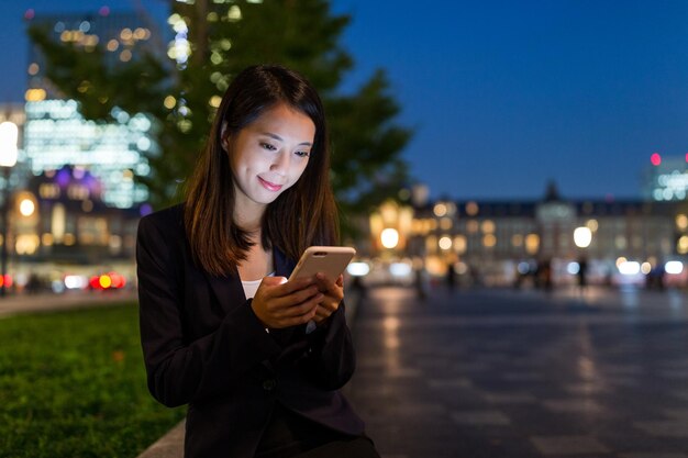 Geschäftsfrau nutzt Handy nachts