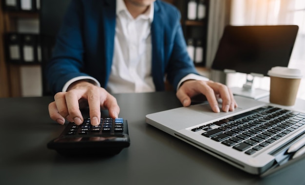 Geschäftsfrau oder Buchhalter schreiben Laptop, der am Schreibtisch arbeitet, um die Kosten zu Hause zu berechnen xA