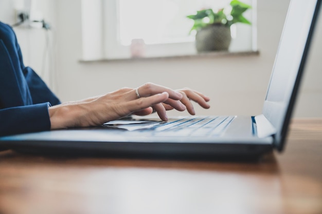 Geschäftsfrau oder Sekretärin, die mit einem Laptop an ihrem Schreibtisch arbeitet