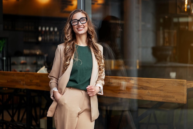 Geschäftsfrau Restaurantbesitzer gekleidet eleganter Hosenanzug, der nahe Restaurant großes Fenster im Freien kaukasische weibliche Brille Geschäftsperson steht