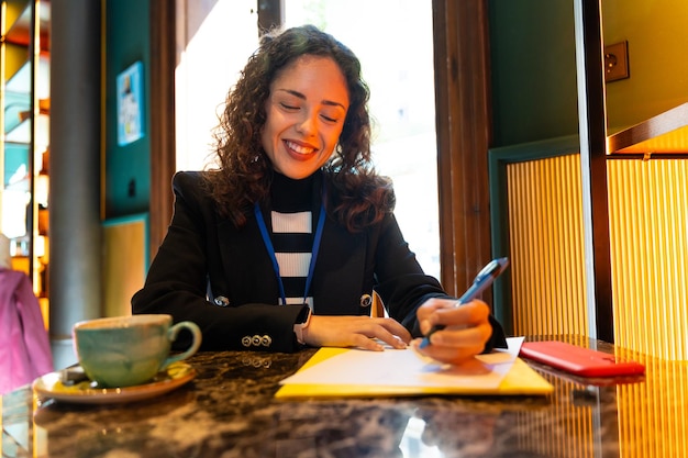 Foto geschäftsfrau schreibt ein dokument in einem lächelnden café