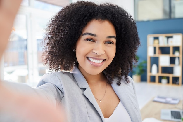 Geschäftsfrau Selfie und Porträt mit glücklichem Lächeln mit Foto des neuen Unternehmensjobs und Mitarbeiterzufriedenheit Social Media Post Glück und Lächeln im Büro am Arbeitsplatz oder Online-Update