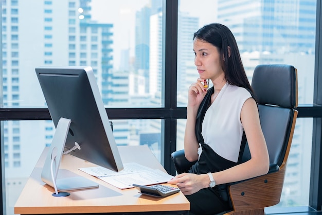 Geschäftsfrau sieht Bildschirm im modernen Büro aus