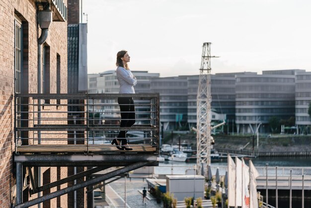 Foto geschäftsfrau steht mit geschlossenen augen auf einem balkon