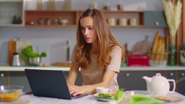 Geschäftsfrau tippt am Laptop am Remote-Arbeitsplatz Frau arbeitet am Laptop
