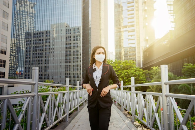 Geschäftsfrau trägt Gesichtsmaske auf Fußgängerbrücke