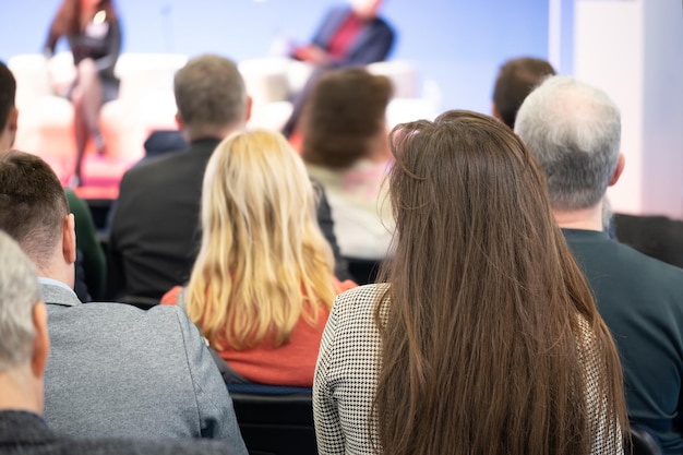 Geschäftsfrau und -leute, die auf dem horizontalen Bild der Konferenz hören