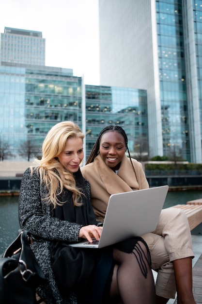 Geschäftsfrauen arbeiten im Freien mit einem Laptop