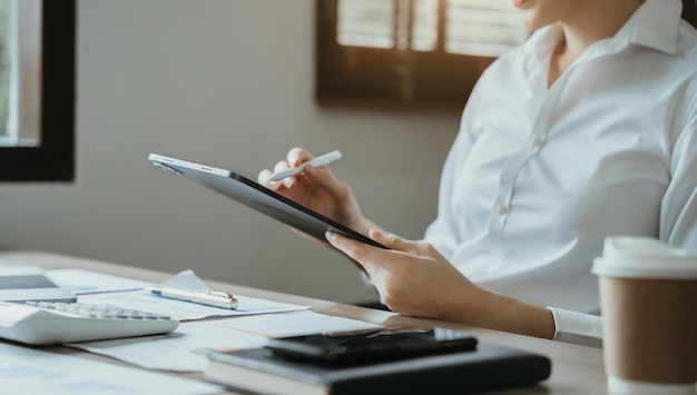 Geschäftsfrauen arbeiten mit Tablet- und Laptop-Computern mit Dokumenten auf dem Schreibtisch im modernen Büro